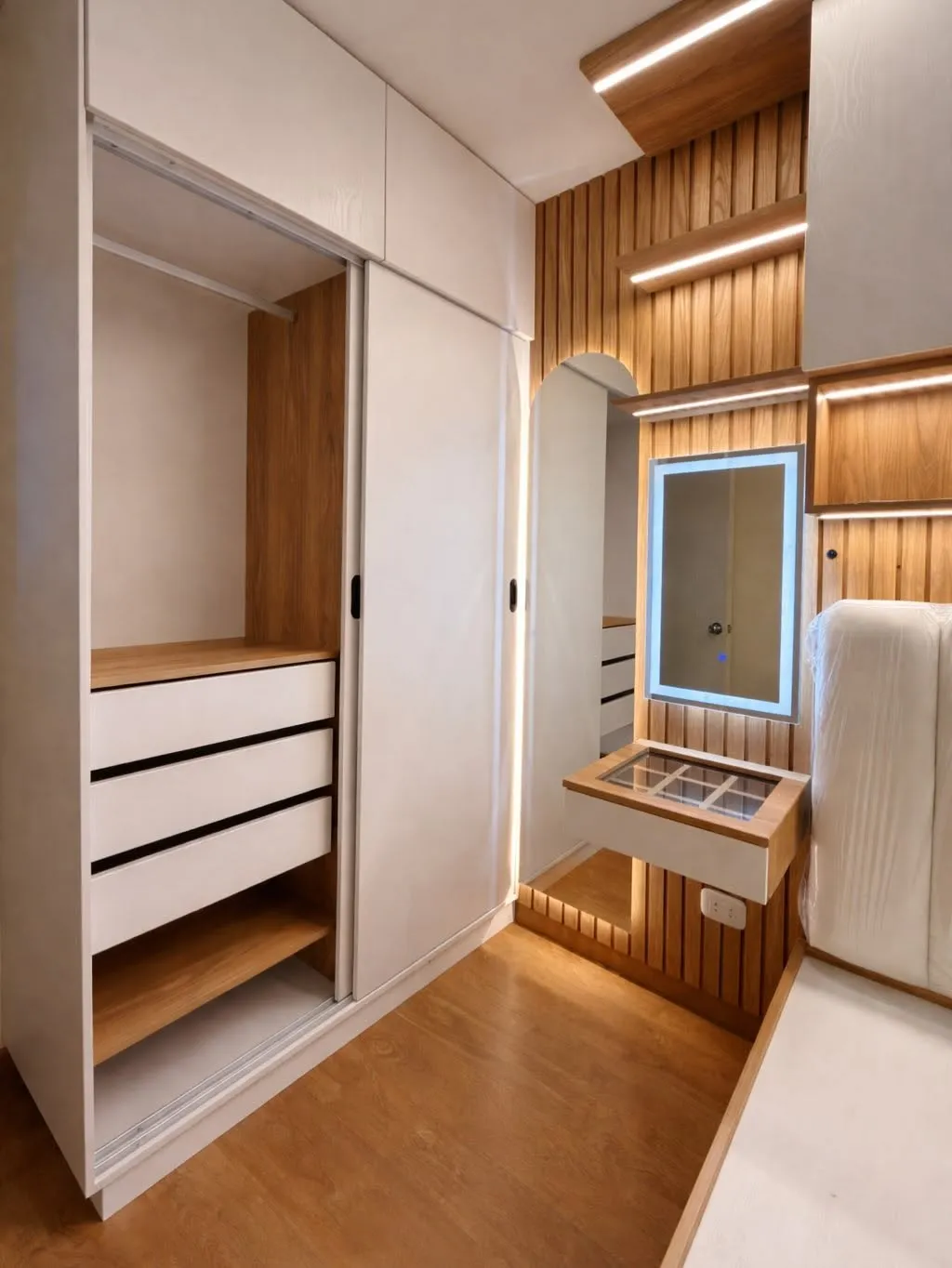 Clóset a medida con cajonería blanca, puertas corredizas y espejo retroiluminado junto al tocador