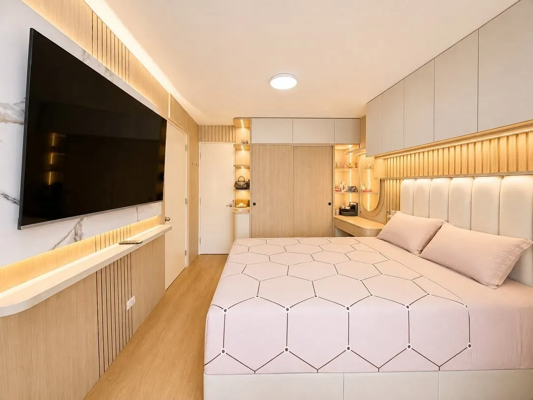 Dormitorio con televisor sobre repisa flotante de madera, panel de listones y luz LED indirecta