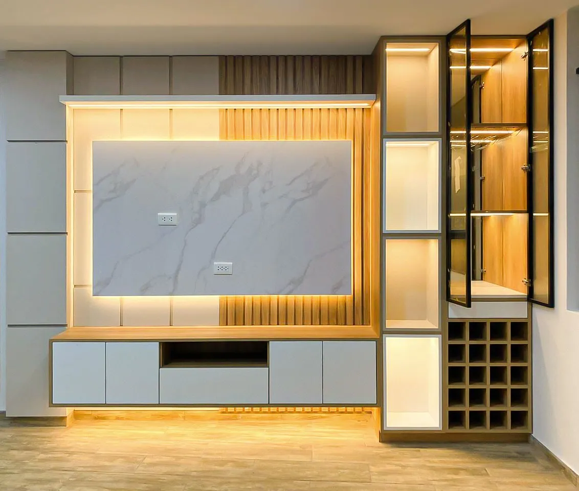 Muro de TV con fondo de porcelanato efecto mármol retroiluminado en cálido, vitrina de marco negro y cava de vino integrada — Santiago de Surco